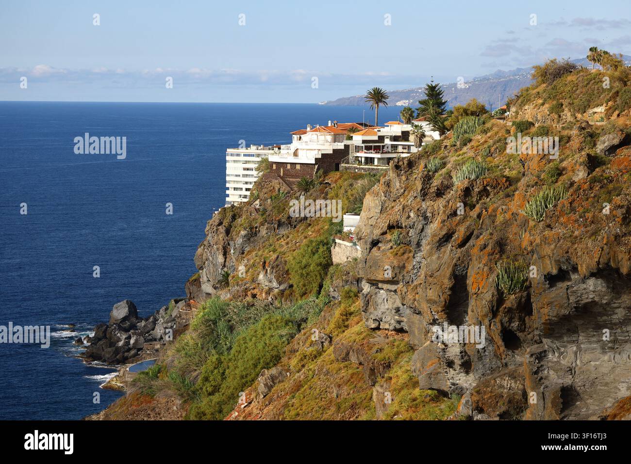 Eleganti case di lusso costruite su drammatiche scogliere vulcaniche che si affacciano sull'Oceano Atlantico a Tenerife, Isole Canarie. Foto Stock