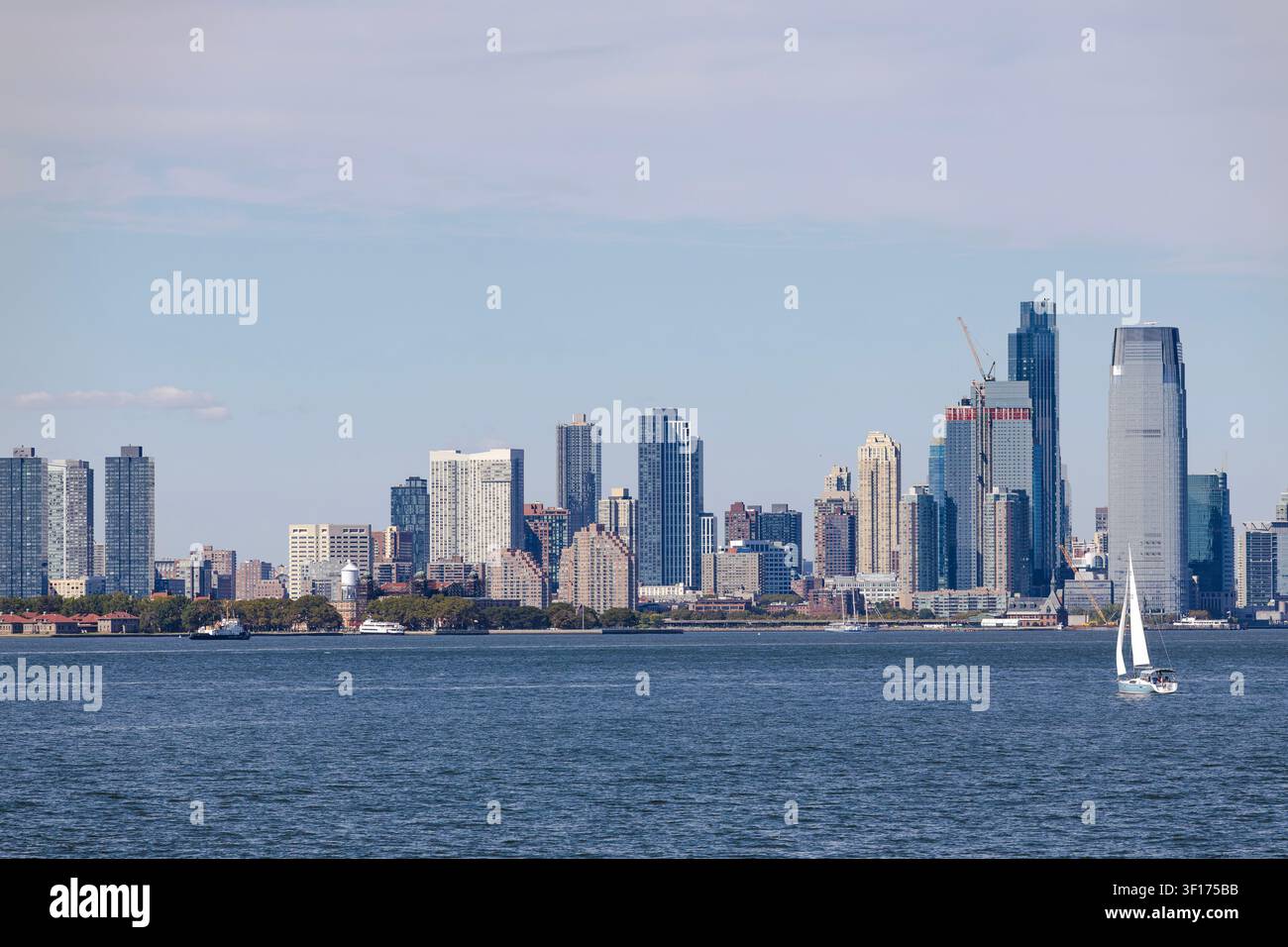Yacht a vela che navigano sulla Baia di Hudson con i grattacieli di New York sullo sfondo Foto Stock