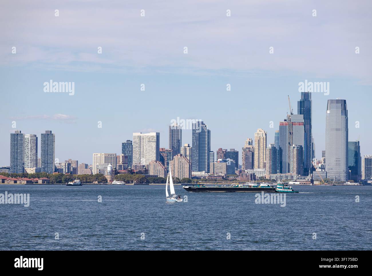 Yacht a vela che navigano sulla Baia di Hudson con i grattacieli di New York sullo sfondo Foto Stock