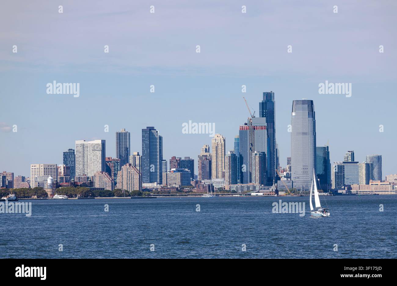 Yacht a vela che navigano sulla Baia di Hudson con i grattacieli di New York sullo sfondo Foto Stock