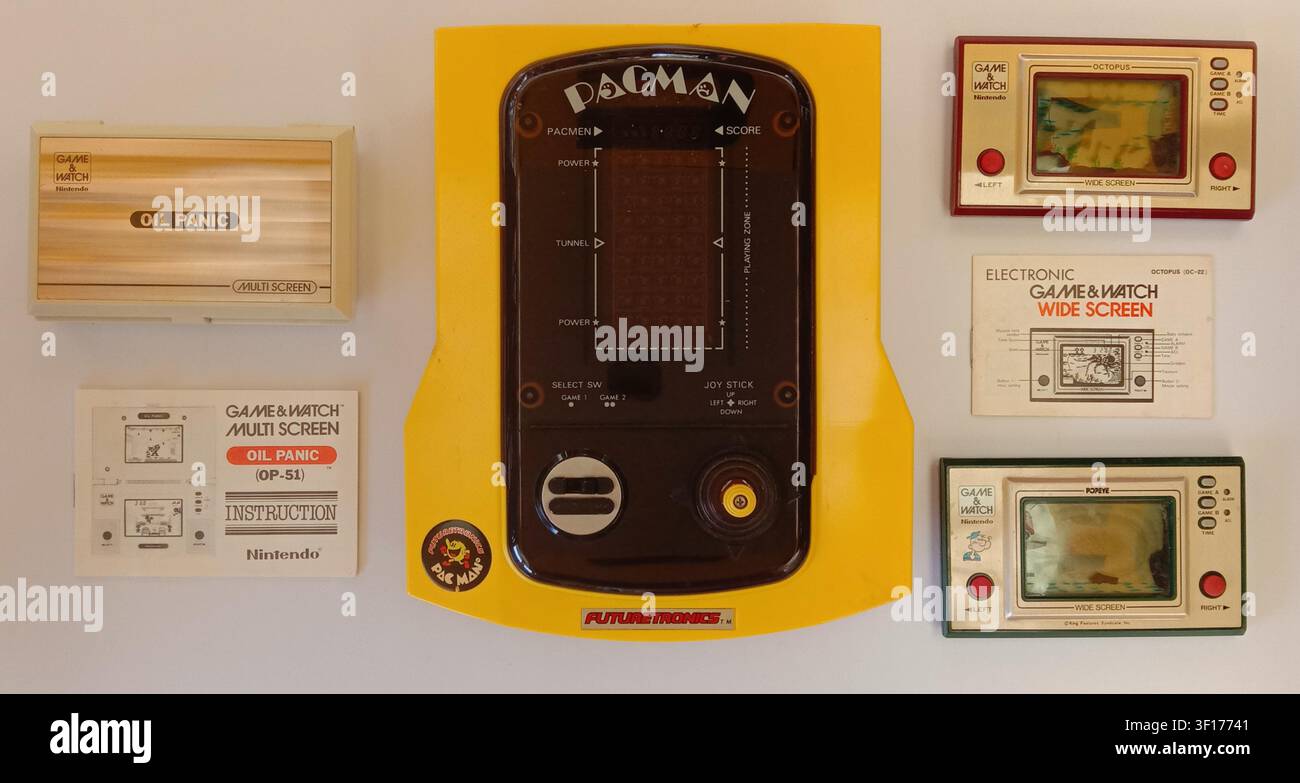 Collezione flat-lay di giochi per arcade elettronici portatili vintage degli anni '80. Comprende Tomy Futuretronics Pac-Man, Oil Panic, Popeye. Foto Stock
