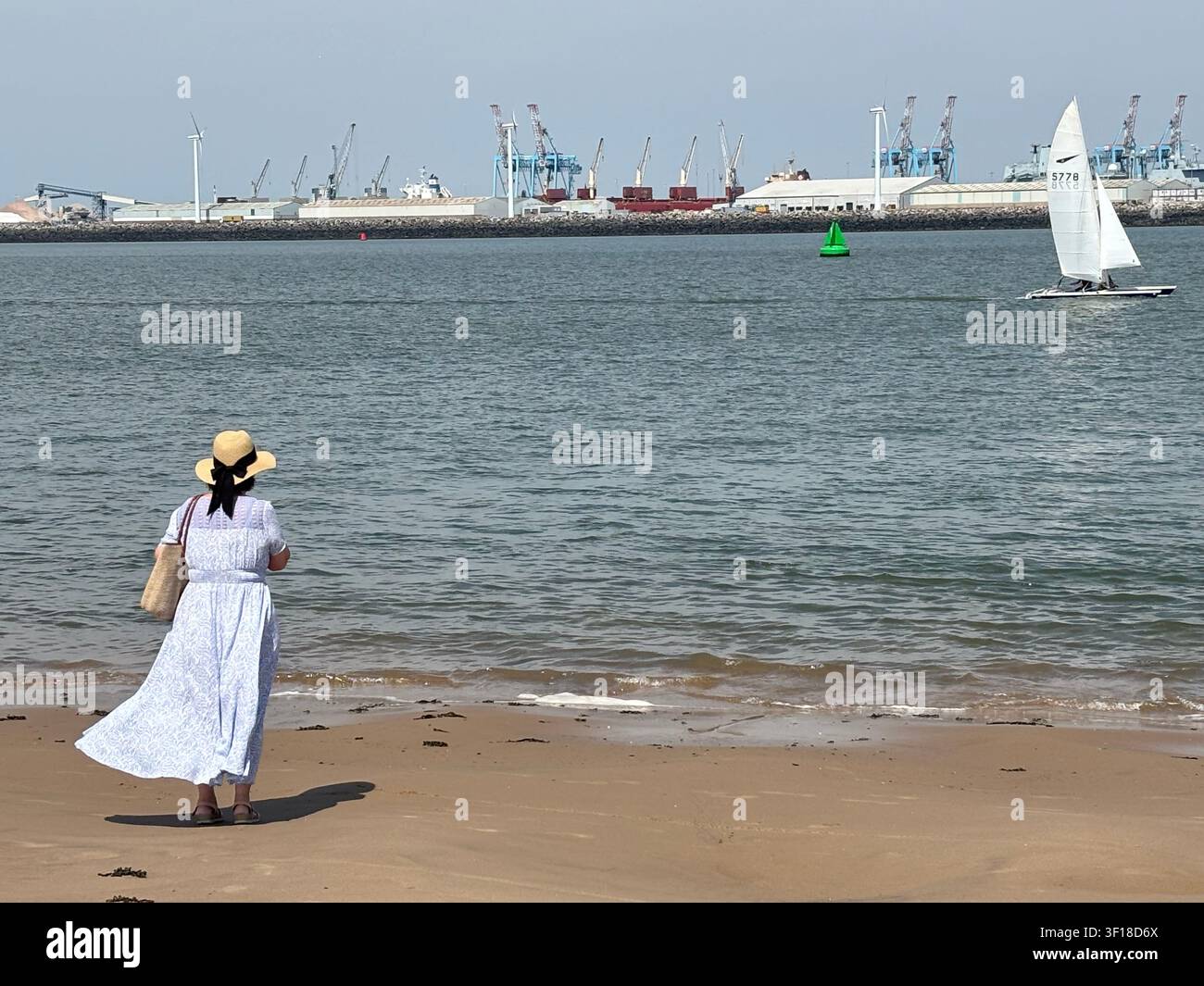Navigando…Una figura solitaria osserva il sartiame che scivola dolcemente lungo il fiume Mersey. - Immagine stock catturata con smartphone