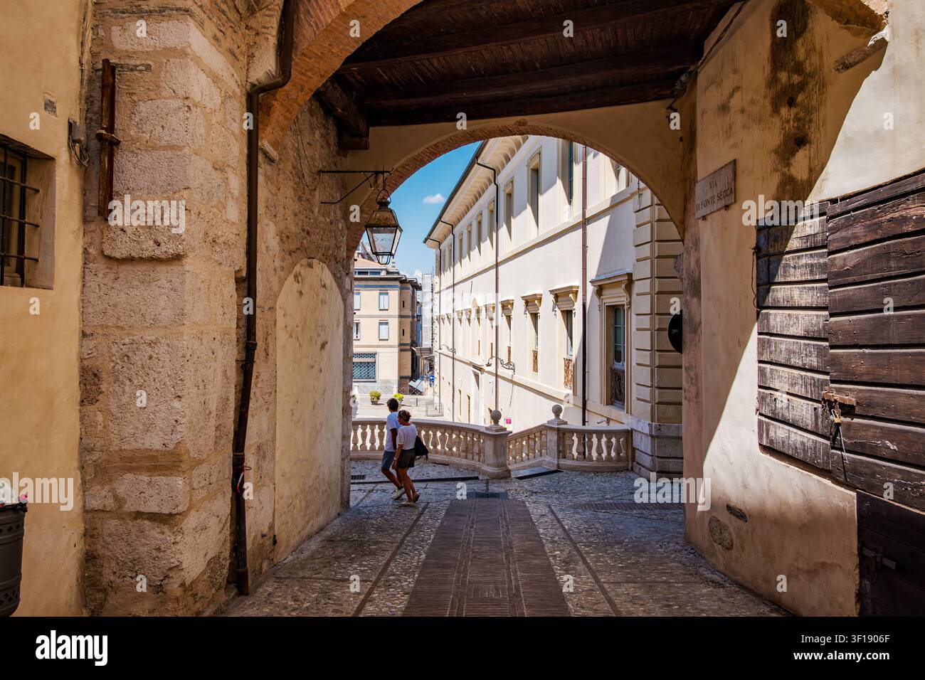 Turisti che camminano nel centro storico di Spoleto godendosi le vacanze estive in Umbria Foto Stock