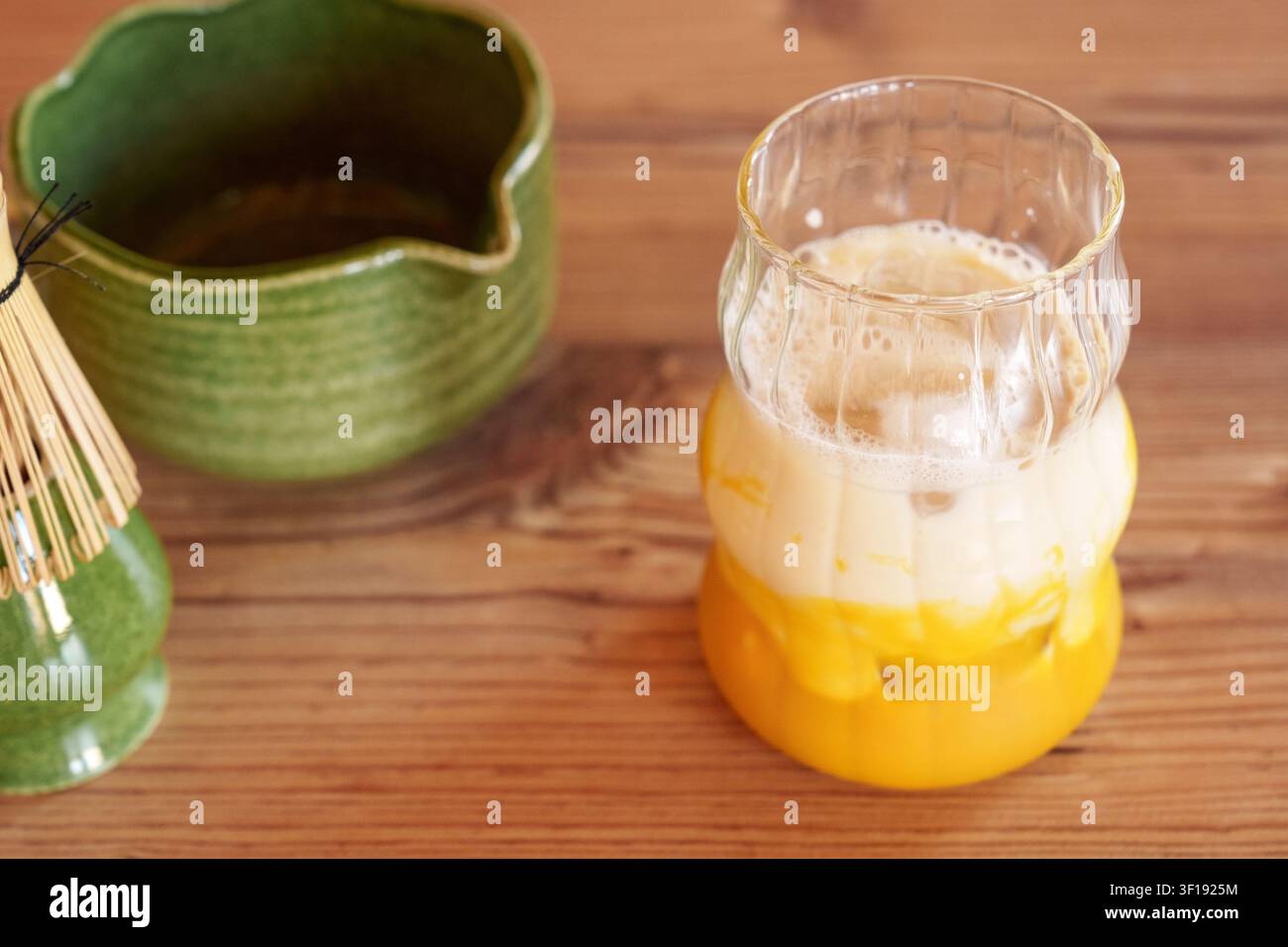 Bicchiere con purea di mango e latte per una ricetta di matcha latte freddo Foto Stock
