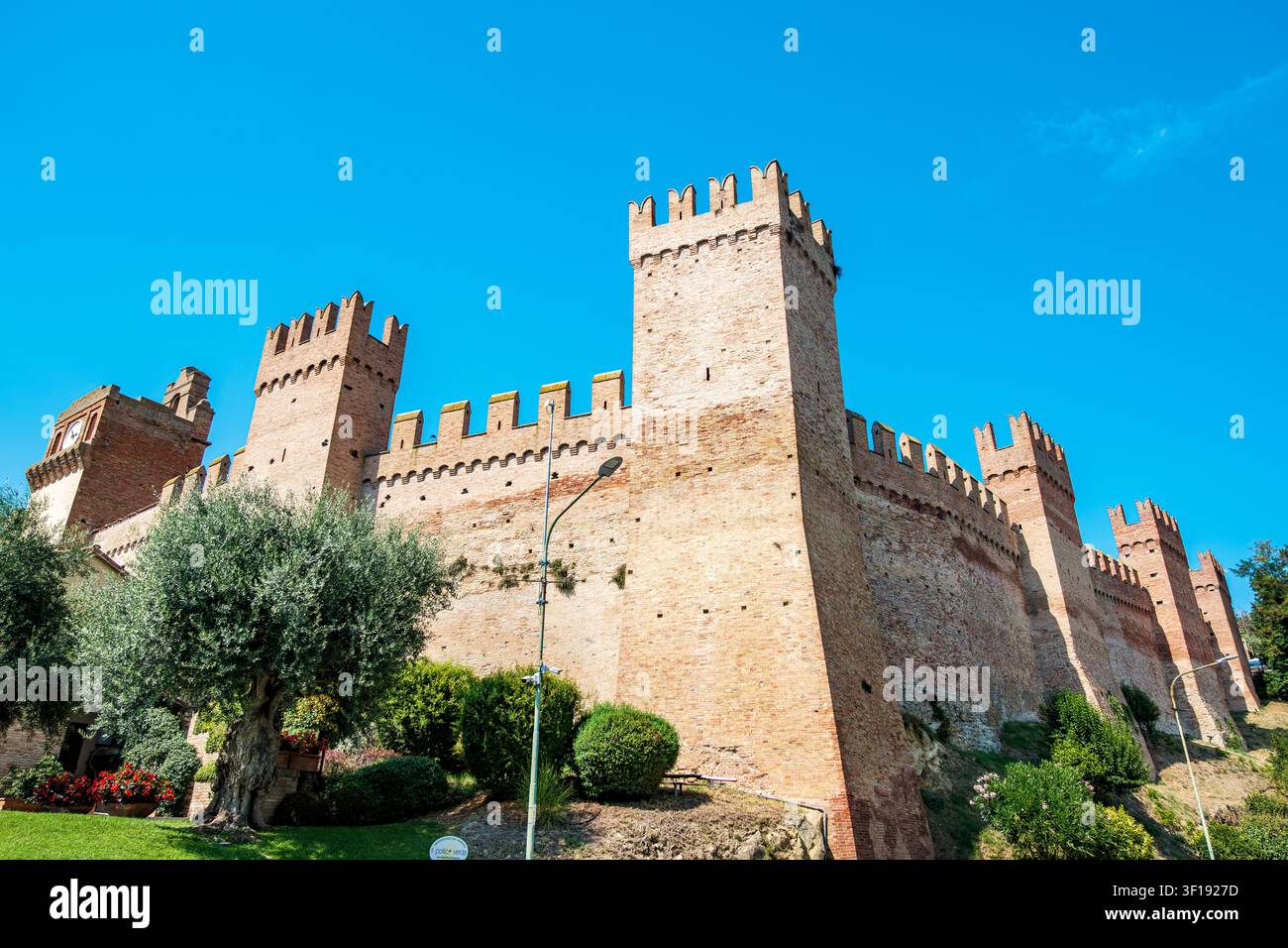 Mura e torri del castello di Gradara che si ergono sotto un cielo blu Foto Stock