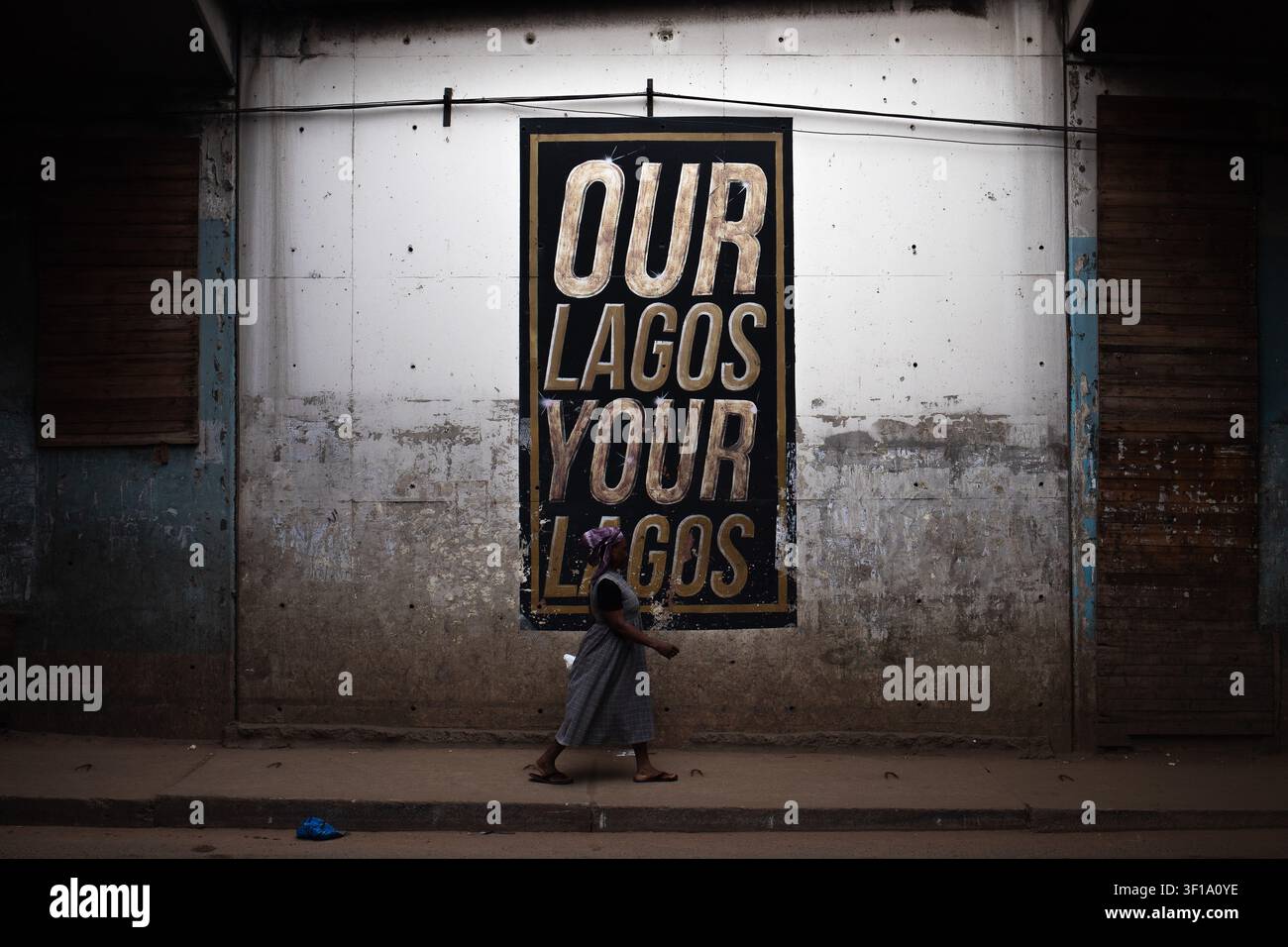 Lagos, Nigeria – 13 giugno 2026. Un pedone passa davanti a un muro con l'iscrizione "LA NOSTRA LAGOS LA TUA LAGOS" a Lagos Foto Stock