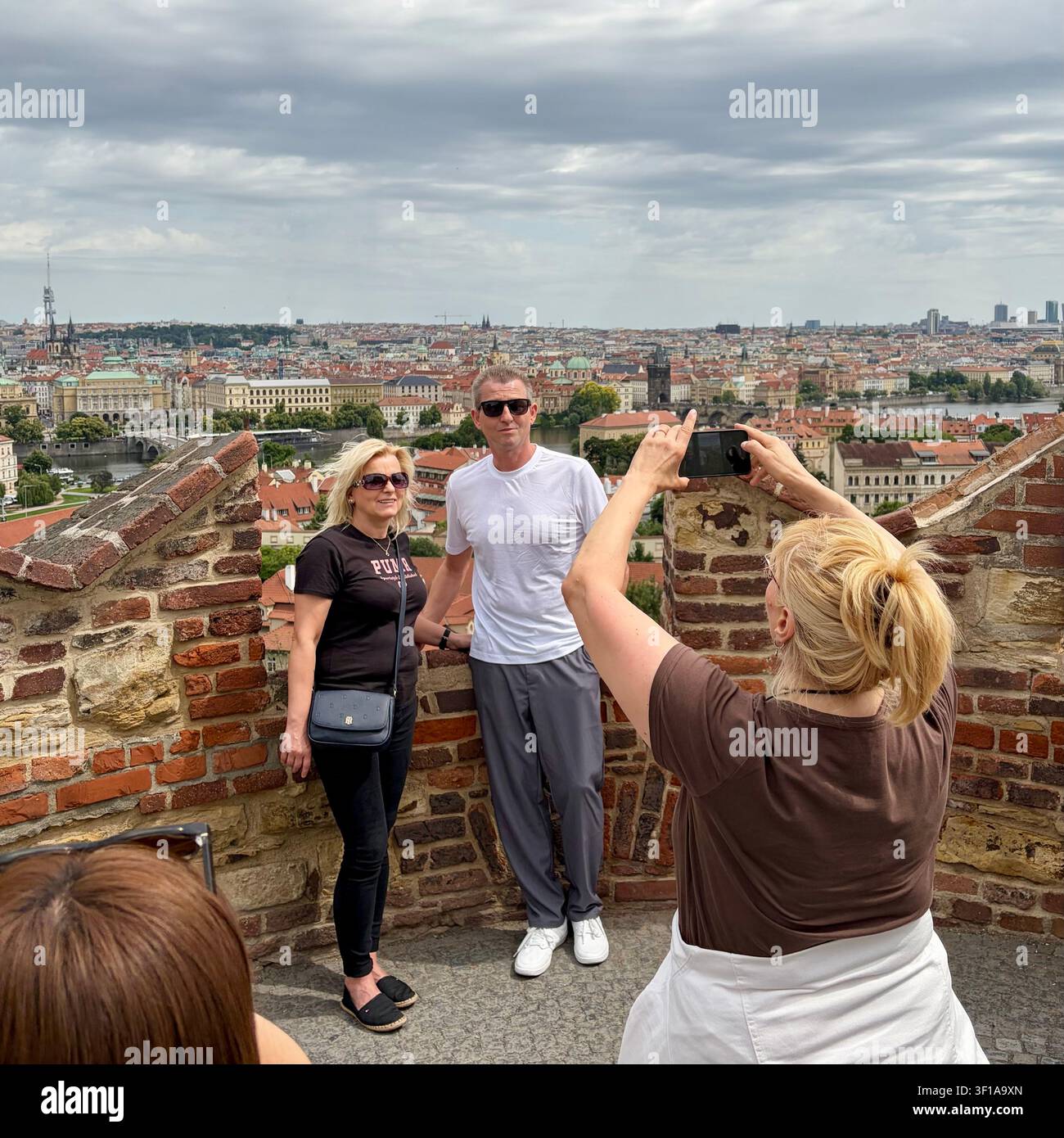 Un uomo e una donna vengono fotografati con una vista di Praga sullo sfondo. - Immagine stock catturata con smartphone