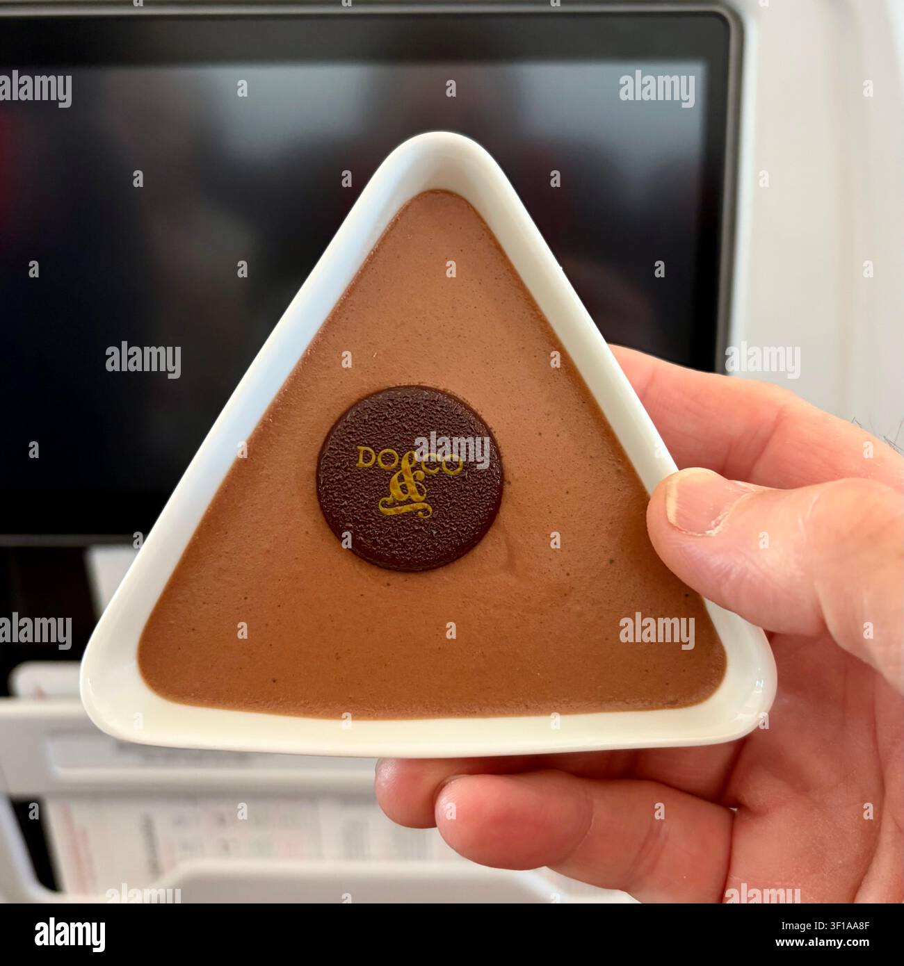 La mousse al cioccolato viene servita in una ciotola triangolare su un aereo. Foto Stock