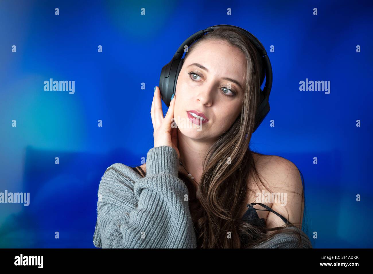 Giovane donna che ascolta musica con cuffie senza fili provando emozione profonda e relax Foto Stock