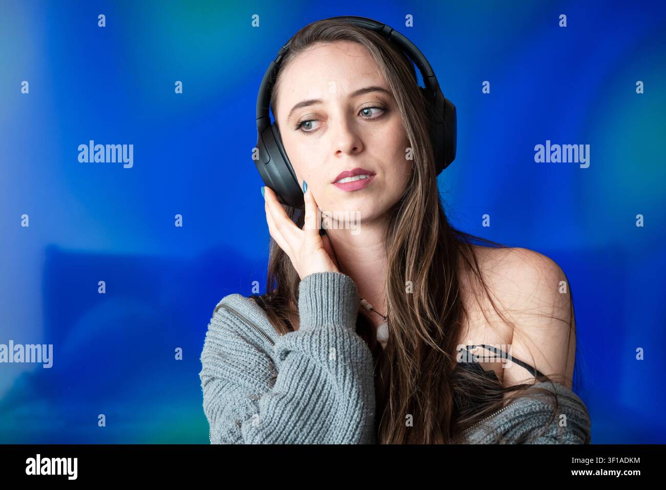 Giovane donna che ascolta musica con cuffie senza fili provando emozione profonda e relax Foto Stock