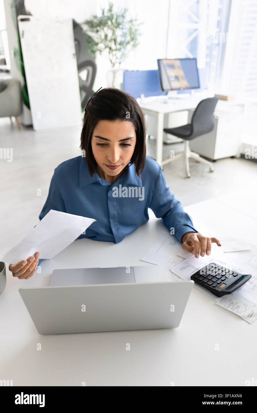 Contabile che verifica le ricevute e inserisce i dati finanziari Foto Stock