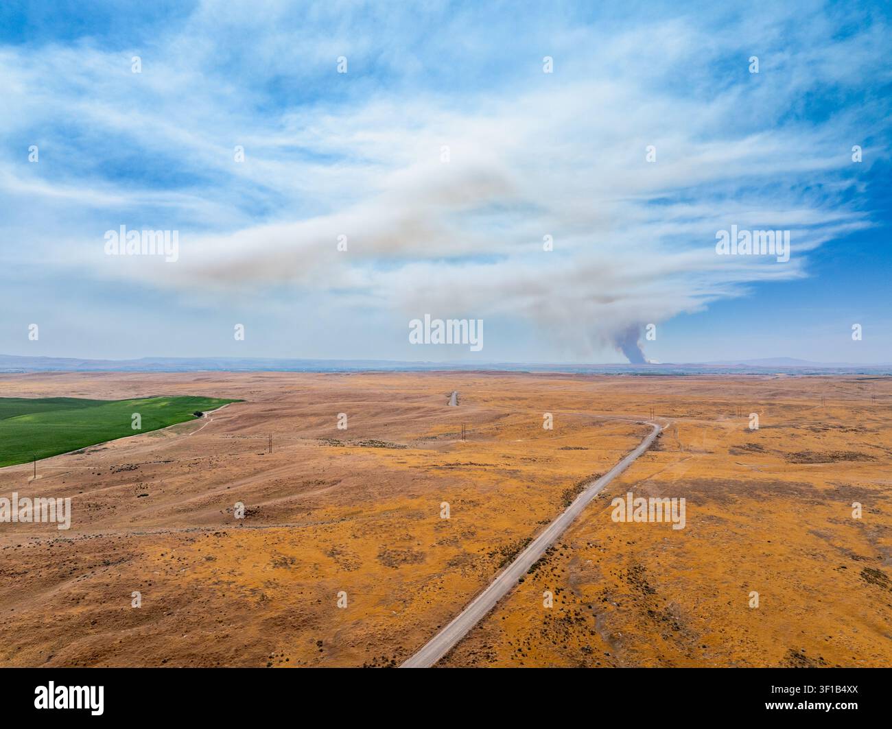 Ampio campo aperto sotto un cielo sereno con nuvole Foto Stock