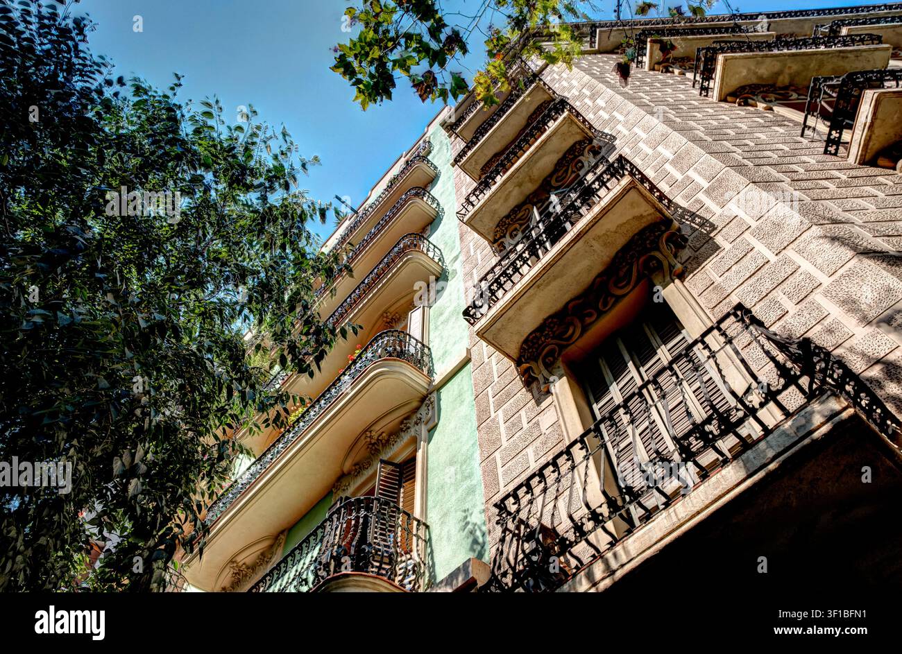 Facciate residenziali storiche con balconi in ferro battuto visti dal basso su una strada di Barcellona, Spagna. Foto Stock