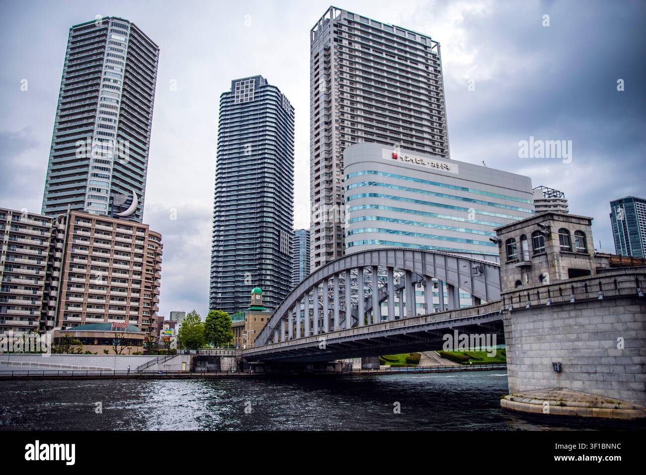 Il ponte storico ad arco in acciaio di Eitai si estende sul fiume Sumida con i moderni grattacieli residenziali di River City 21 sullo sfondo, To Foto Stock