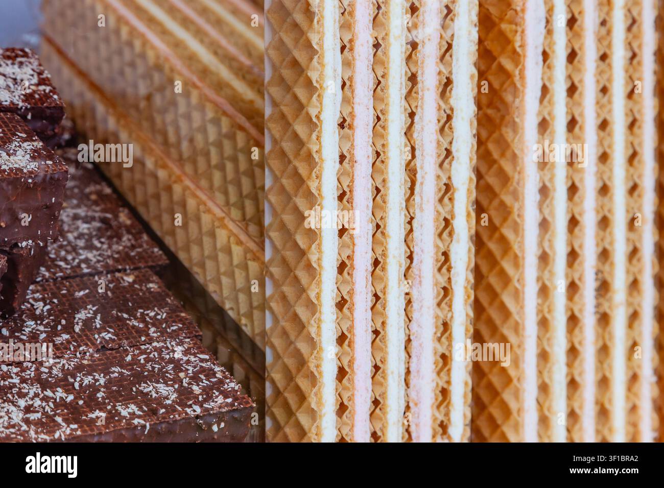 Assortimento di fogli di waffle croccanti con strati di ripieno alla crema dolce e blocchi di wafer glassati al cioccolato su un banco del mercato della panetteria Foto Stock