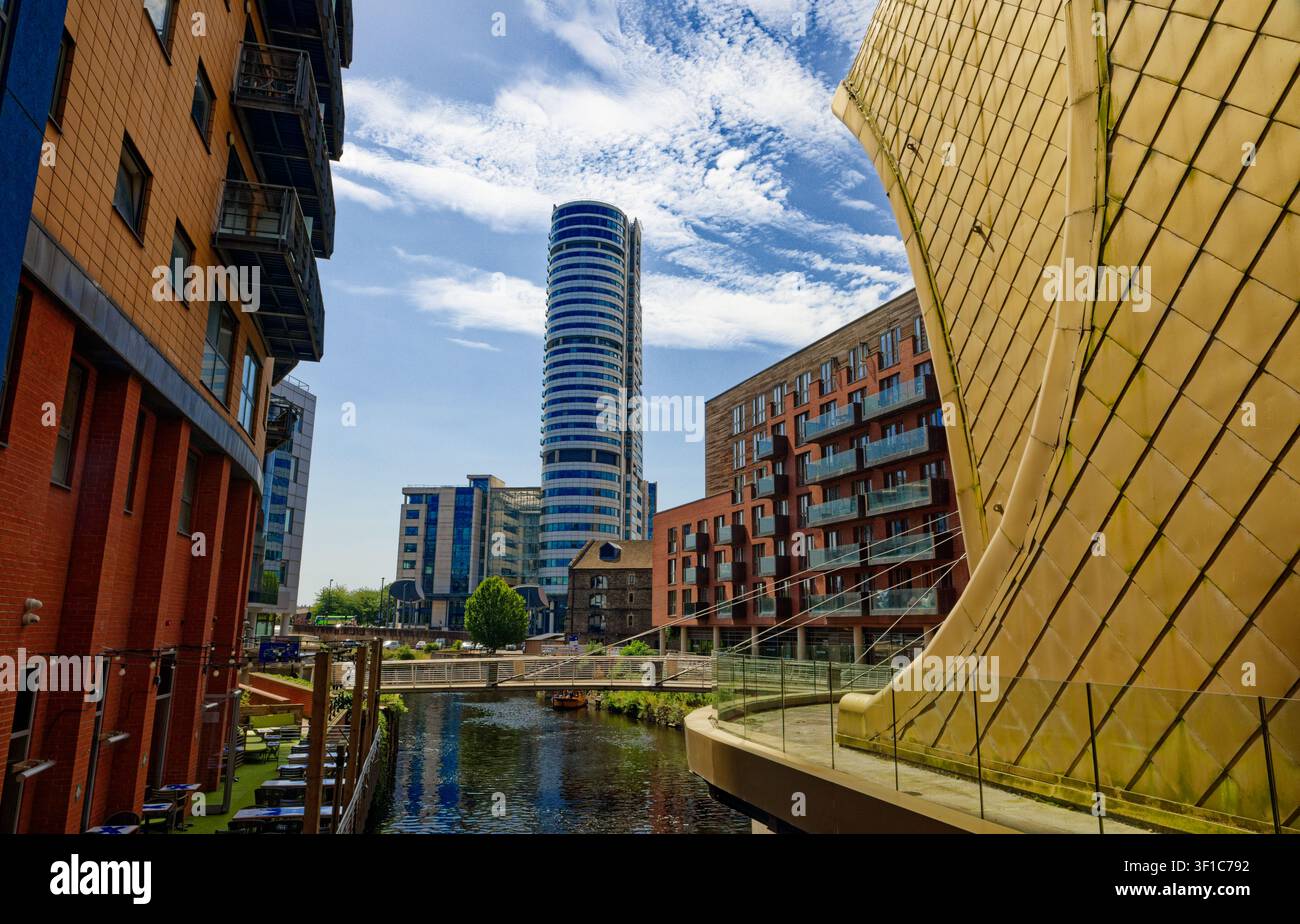 Un alto edificio si erge sopra il fiume Aire con appartamenti sul lungofiume e la curva dell’ingresso sud della stazione di Leeds, West Yorkshire, Inghilterra. Foto Stock