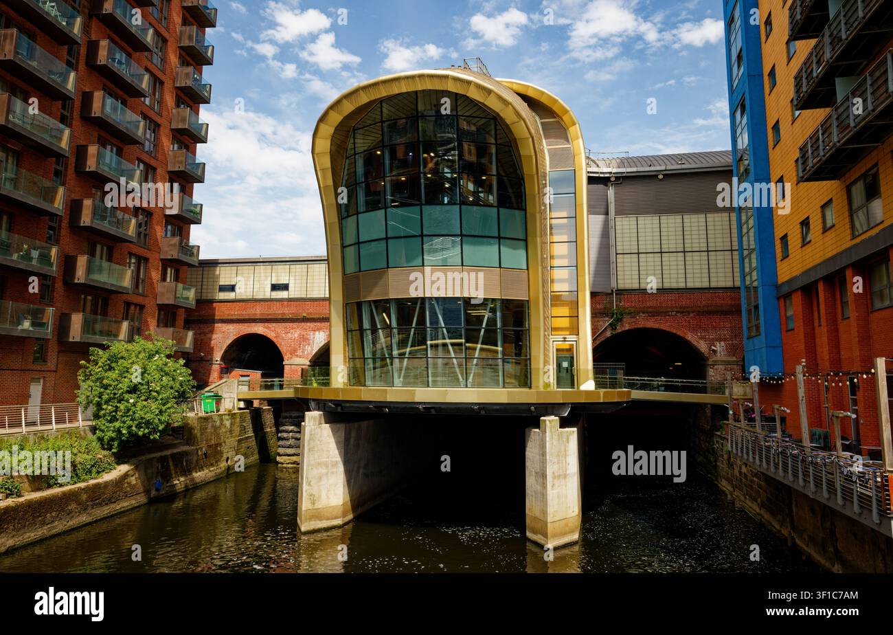 Il fiume Aire emerge da sotto l’ingresso sud della stazione di Leeds City tra gli appartamenti sul fiume, Leeds, West Yorkshire, Inghilterra. Foto Stock