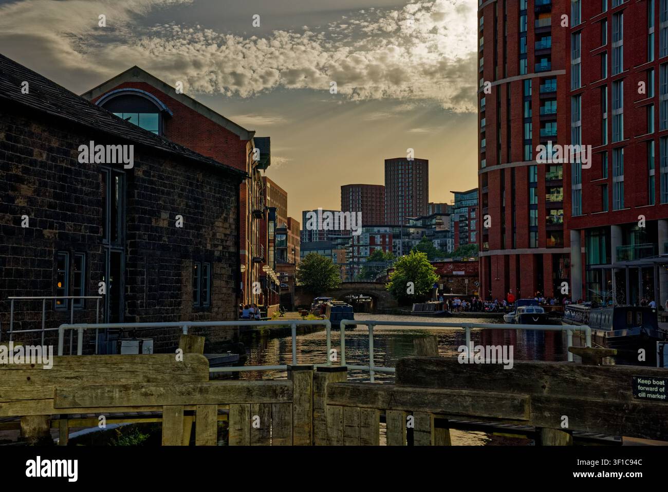 Il sole della sera inizia a svanire oscurando i cieli sopra un canale urbano con chiuse, Granary Wharf, Leeds, West Yorkshire. Foto Stock