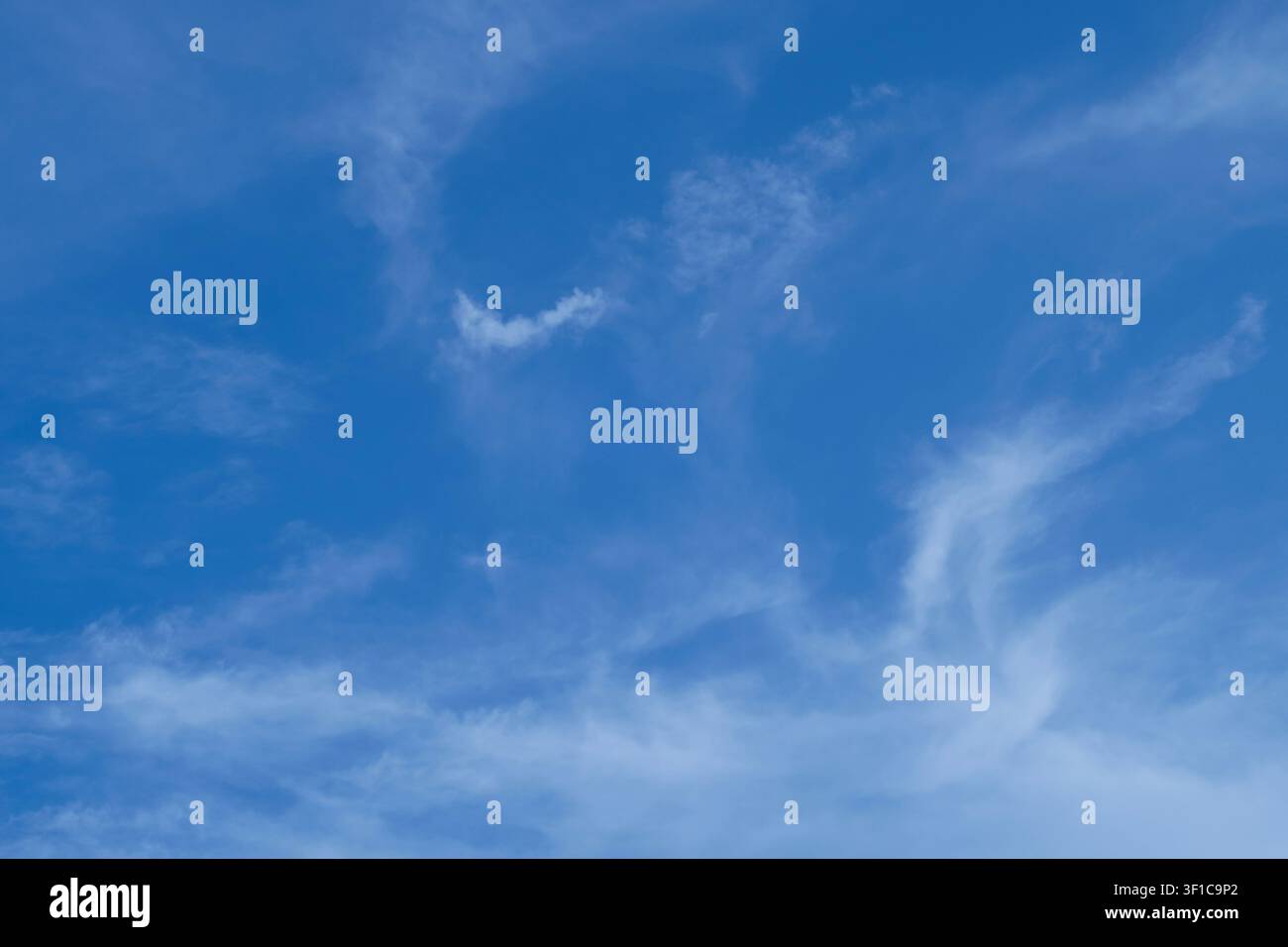 Un sereno cielo blu chiaro pieno di soffici nuvole sparse, perfetto per essere utilizzato come sovrapposizione di sfondo naturale. Foto Stock