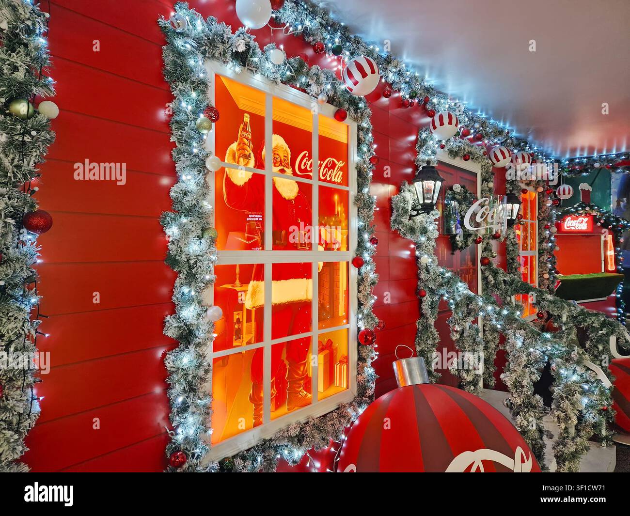 Chișinău, Moldavia – 10 gennaio 2026: una facciata festosa di un chiosco Coca-Cola decorata con ghirlande di pino ghiacciate e luci natalizie scintillanti. Babbo N Foto Stock
