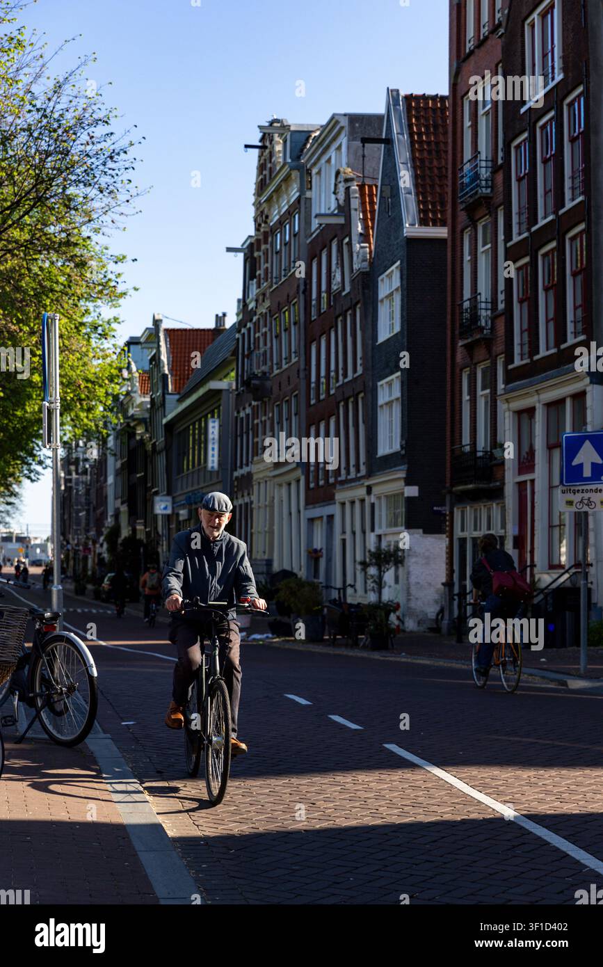 La vita quotidiana ad Amsterdam, capitale dei Paesi Bassi, è dominata dalle biciclette mentre le persone pendolari vanno al lavoro, a scuola e i turisti visitano le attrazioni. Foto Stock