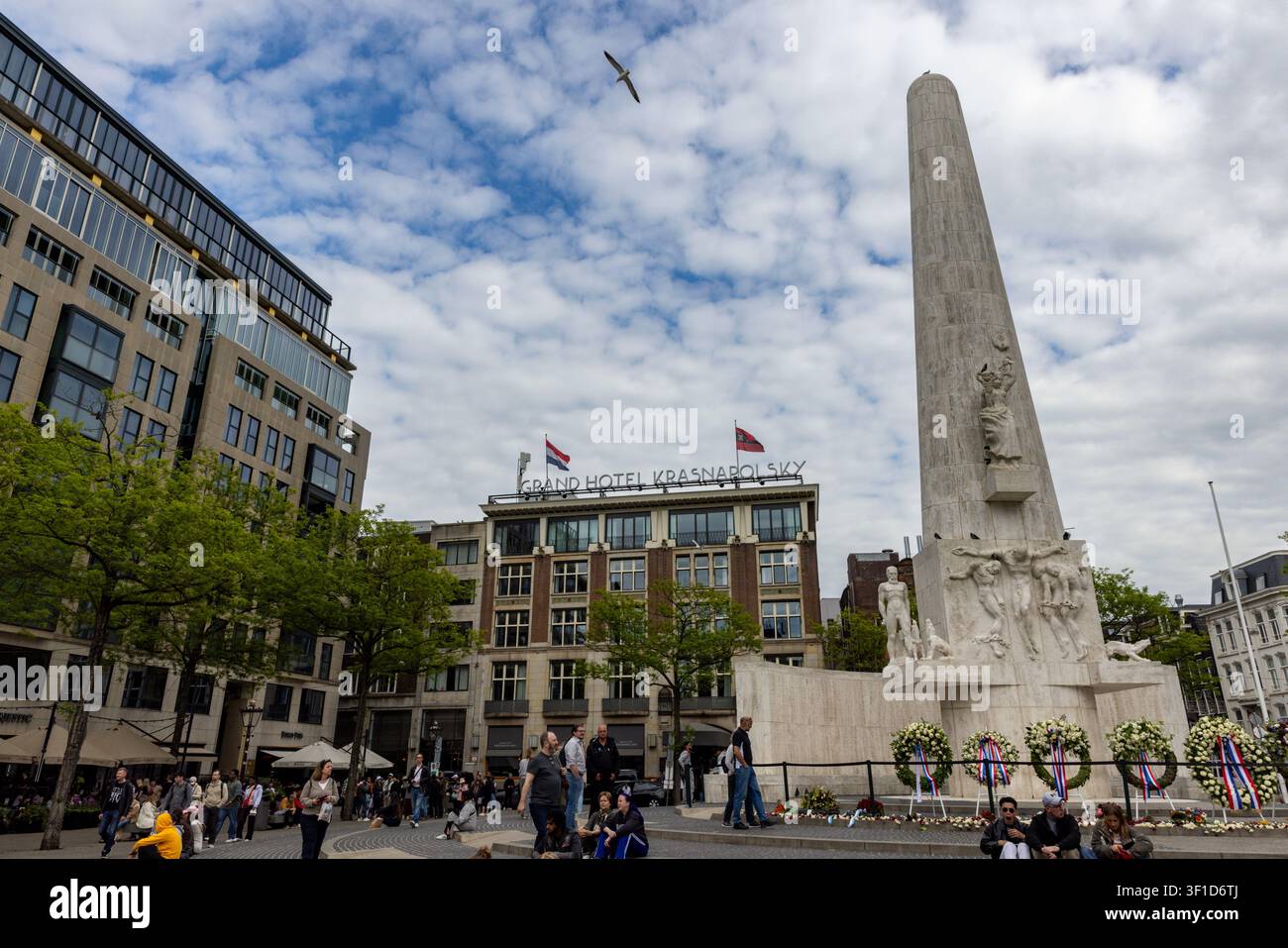 Piazza Dam è ancorata dall'imponente monumento nazionale in travertino bianco dedicato alle vittime della Seconda Guerra Mondiale ad Amsterdam, Paesi Bassi, a maggio Foto Stock