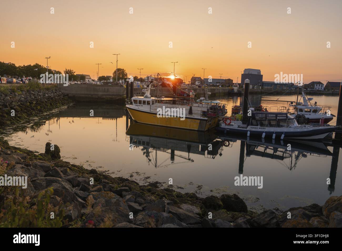Porto con barche da pesca e rocce, il tramonto crea un'atmosfera rilassata, Howth, Irlanda Foto Stock