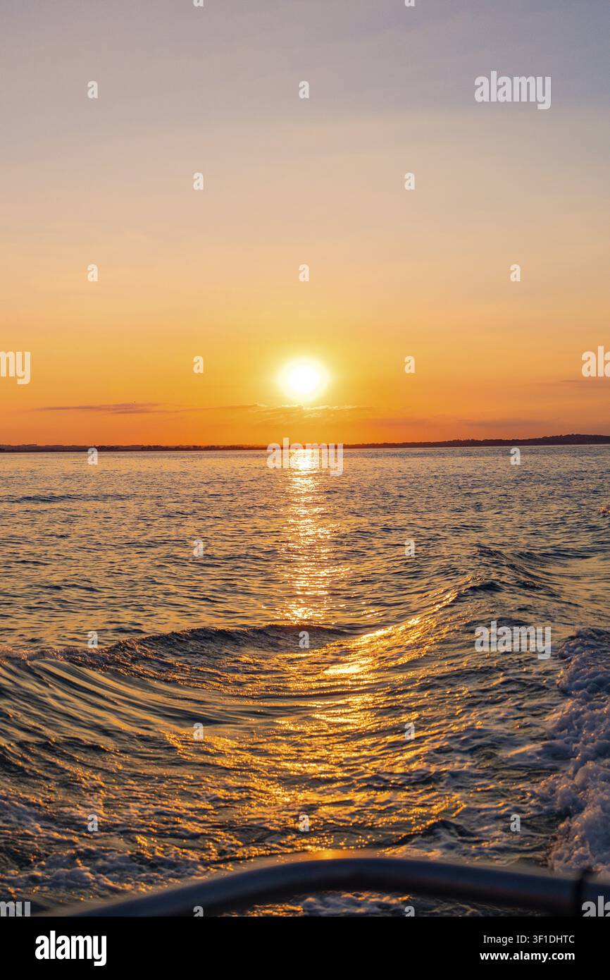 Luce del tramonto su un mare calmo con onde leggere, Howth, Irlanda Foto Stock
