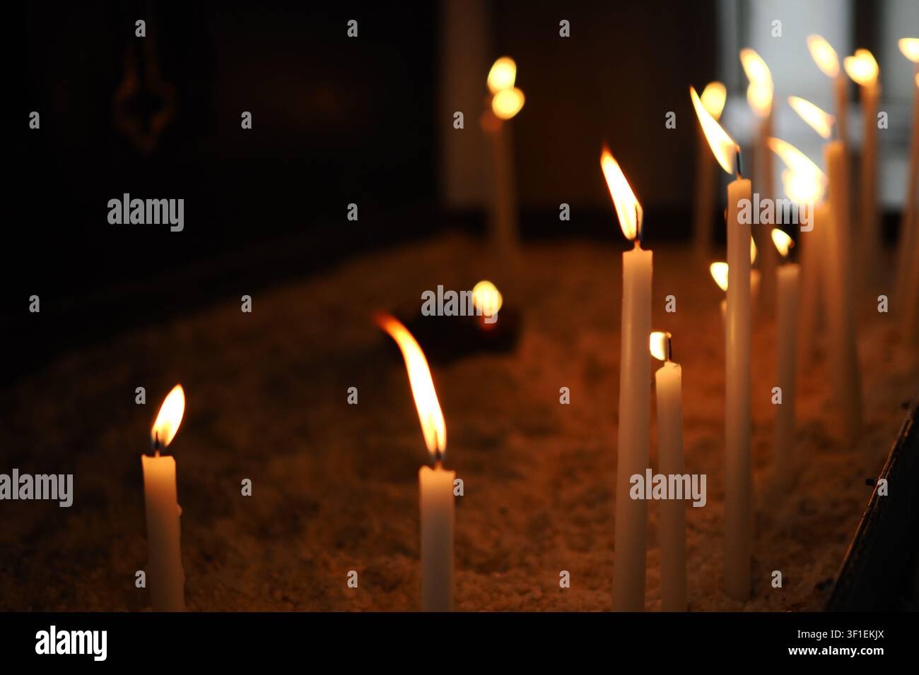 Candele che bruciano in un ambiente buio Foto Stock