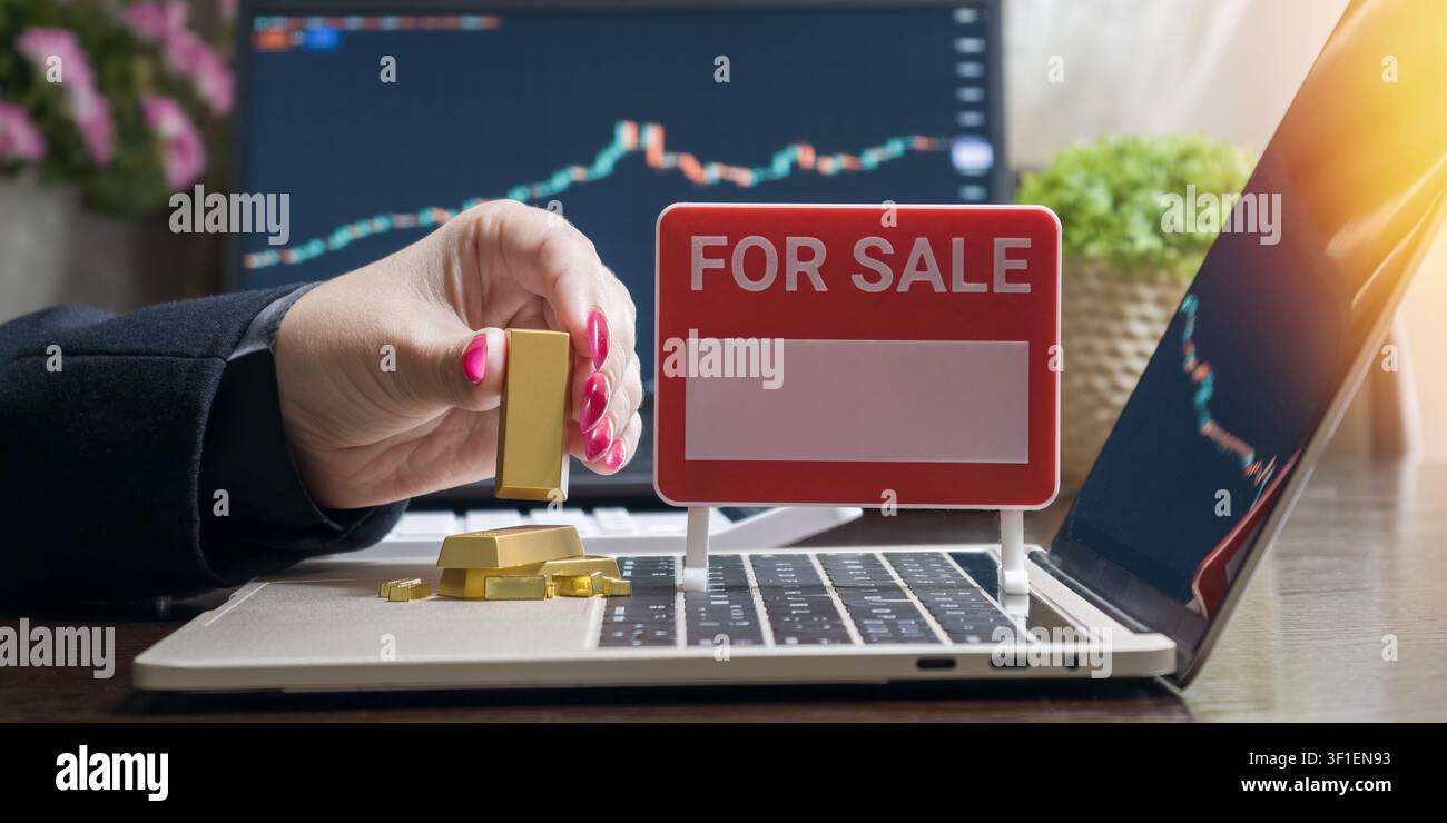 Vendita di investimenti in oro. Donna d'affari che negozia metalli preziosi online con grafici finanziari. Foto Stock