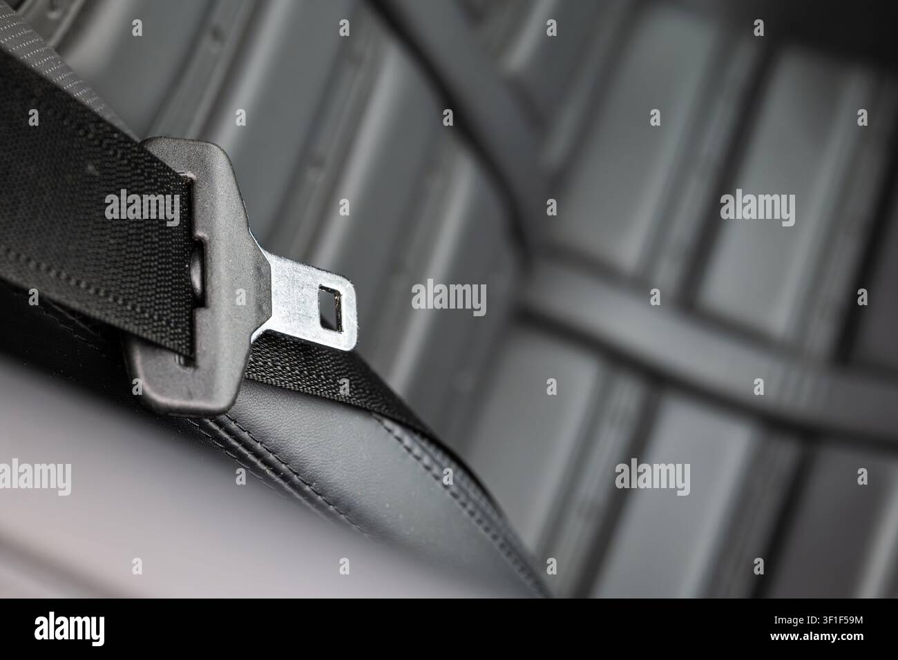 Studio fotografico dettagliato del complessivo fibbia e cinghia della cintura di sicurezza, che sottolinea l'estetica industriale e i materiali di alta qualità del sistema di ritenuta Foto Stock
