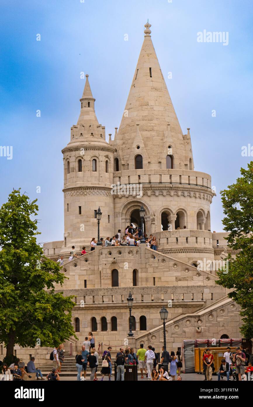 Veduta vivace di una giornata estiva di folle di turisti che esplorano le torri e le scale in pietra neo-gotiche della storica Bastione dei Pescatori a Budapest Foto Stock
