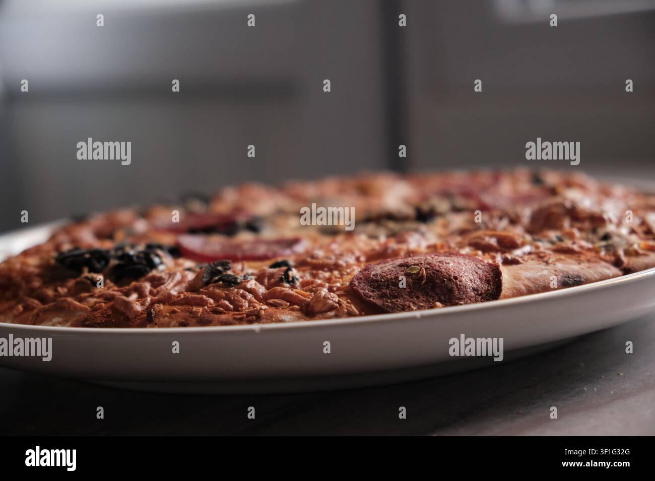 Prima di una mini pizza fatta in casa cotta al forno, ricoperta di formaggio fuso e foglie di basilico fresco Foto Stock