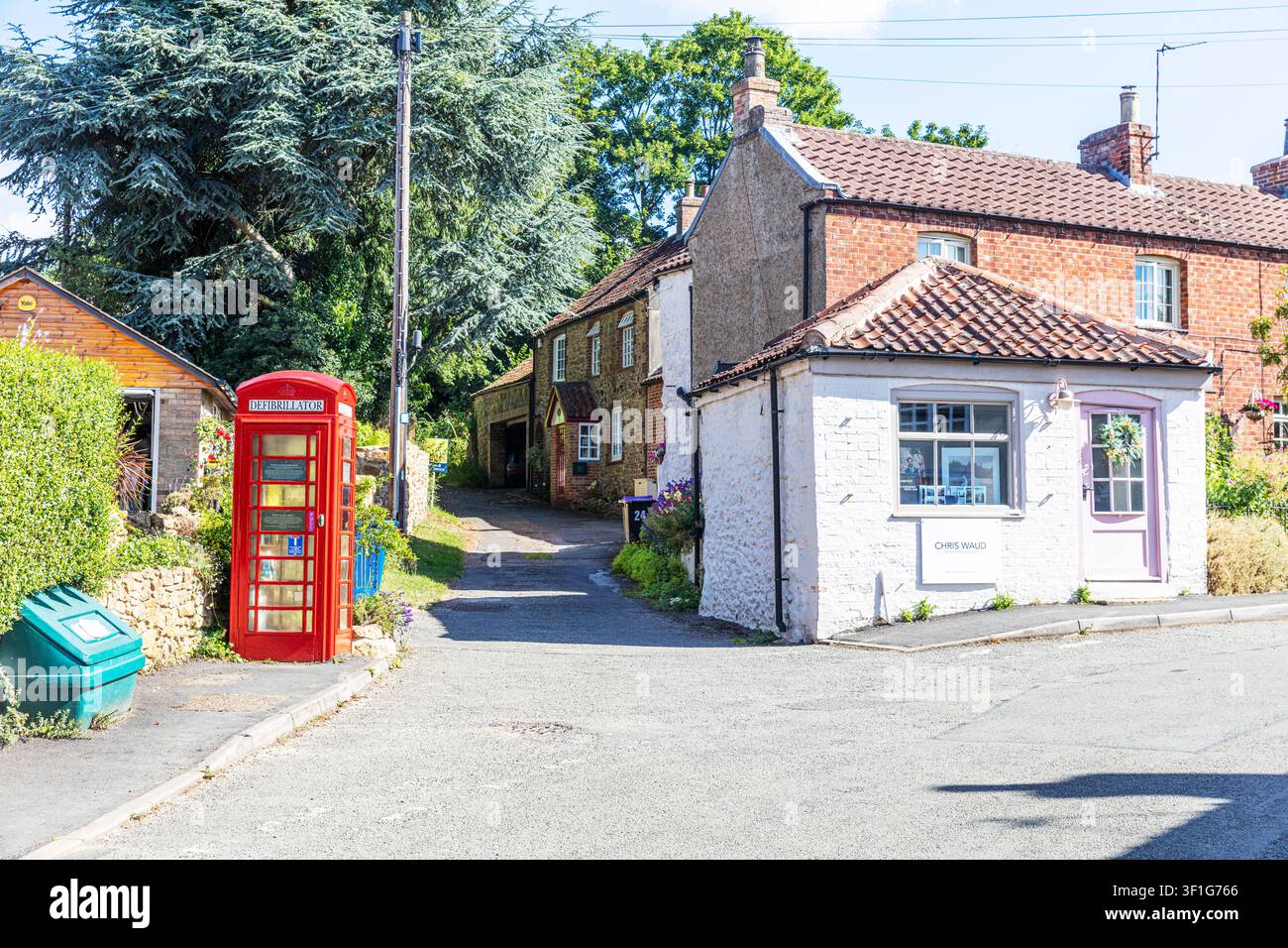 Tealby, Lincolnshire, UK, Inghilterra, Una scena tradizionale della strada del villaggio a Tealby, Lincolnshire, con una classica cabina telefonica britannica rossa accanto a br Foto Stock