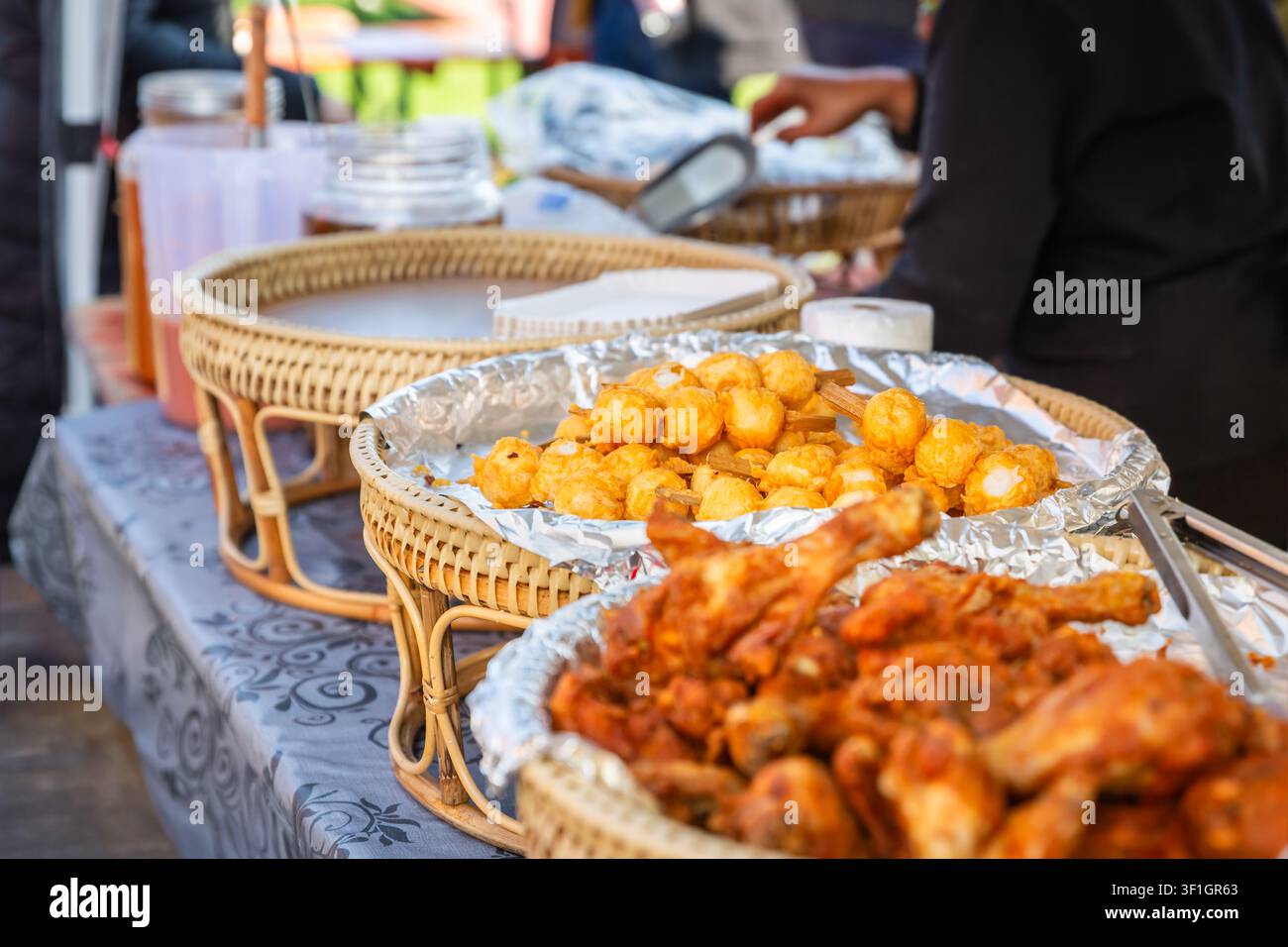 Delizioso pollo fritto e polpette di pesce servite a uno stand gastronomico all'aperto Foto Stock