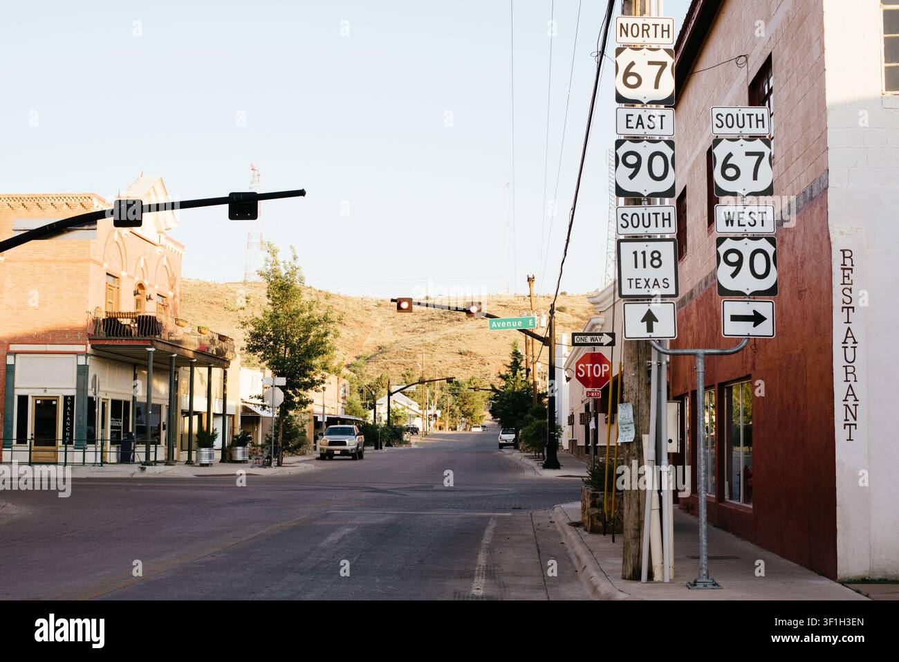 I segnali stradali delle autostrade indicano le U.S. Routes 67 e 90 e la Texas State Highway 118 a un incrocio tranquillo del centro di Alpine, Contea di Brewster, Texas occidentale, USA Foto Stock