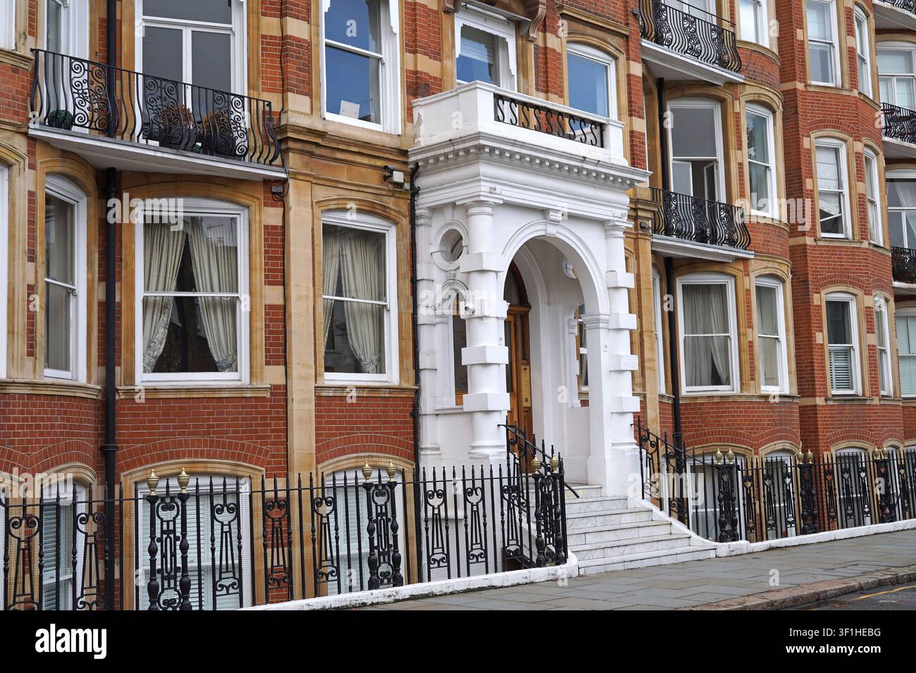 Ingresso con portico bianco di un edificio residenziale in mattoni rossi a Londra Foto Stock
