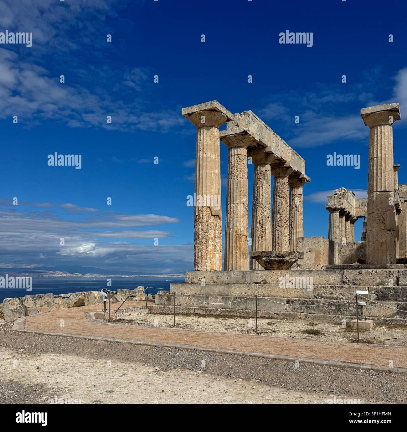 Tempio di Aphaia Colonne doriche antiche che si affacciano sul golfo Saronico sull'isola di Ägina, Grecia, sotto un drammatico cielo blu. - Immagine stock catturata con smartphone