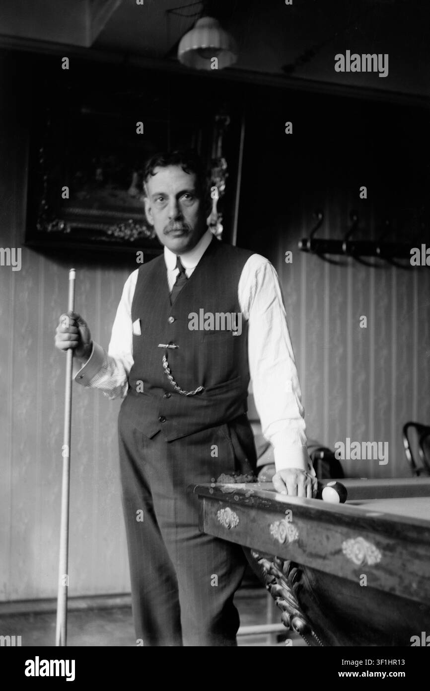Il professionista cubano del biliardo Alfredo de Oro (1863–1948) in posa accanto a un tavolo da biliardo. Figura leggendaria negli sport del biliardo, De Oro ha vinto numerosi titoli mondiali sia nel biliardo continuo che nel biliardo a tre bandiere. È stato inserito postumo nella Billiard Congress of America Hall of Fame nel 1967. Data della foto: circa 1910-1915. Foto Stock