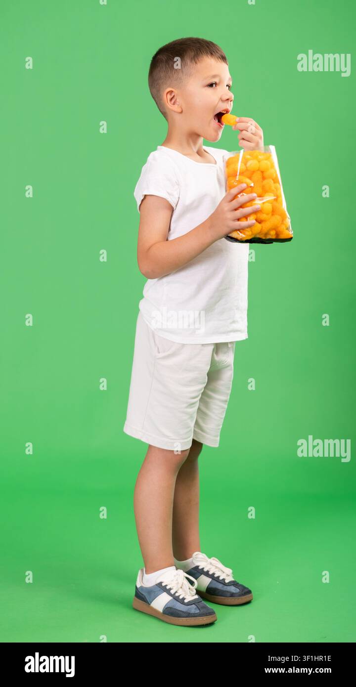 Ragazzo e bastoncini di mais, spuntino dolce Foto Stock