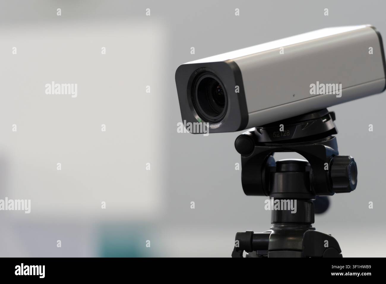 Fotocamera rettangolare montata su una testa di treppiede, primo piano dell'obiettivo e del supporto regolabile in una vetrina di attrezzature. Foto Stock