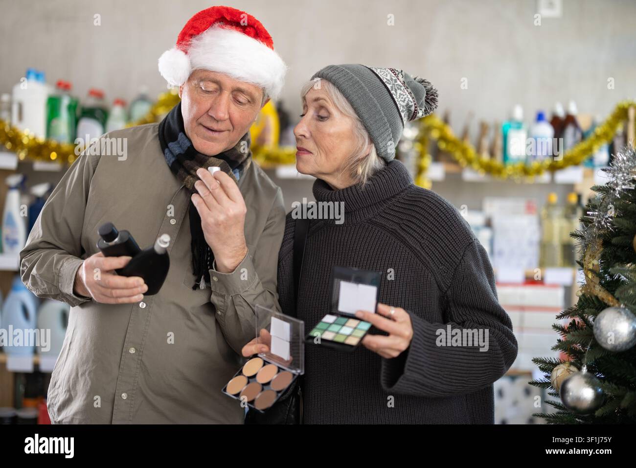 Marito e moglie scelgono il profumo al supermercato per Natale Foto Stock