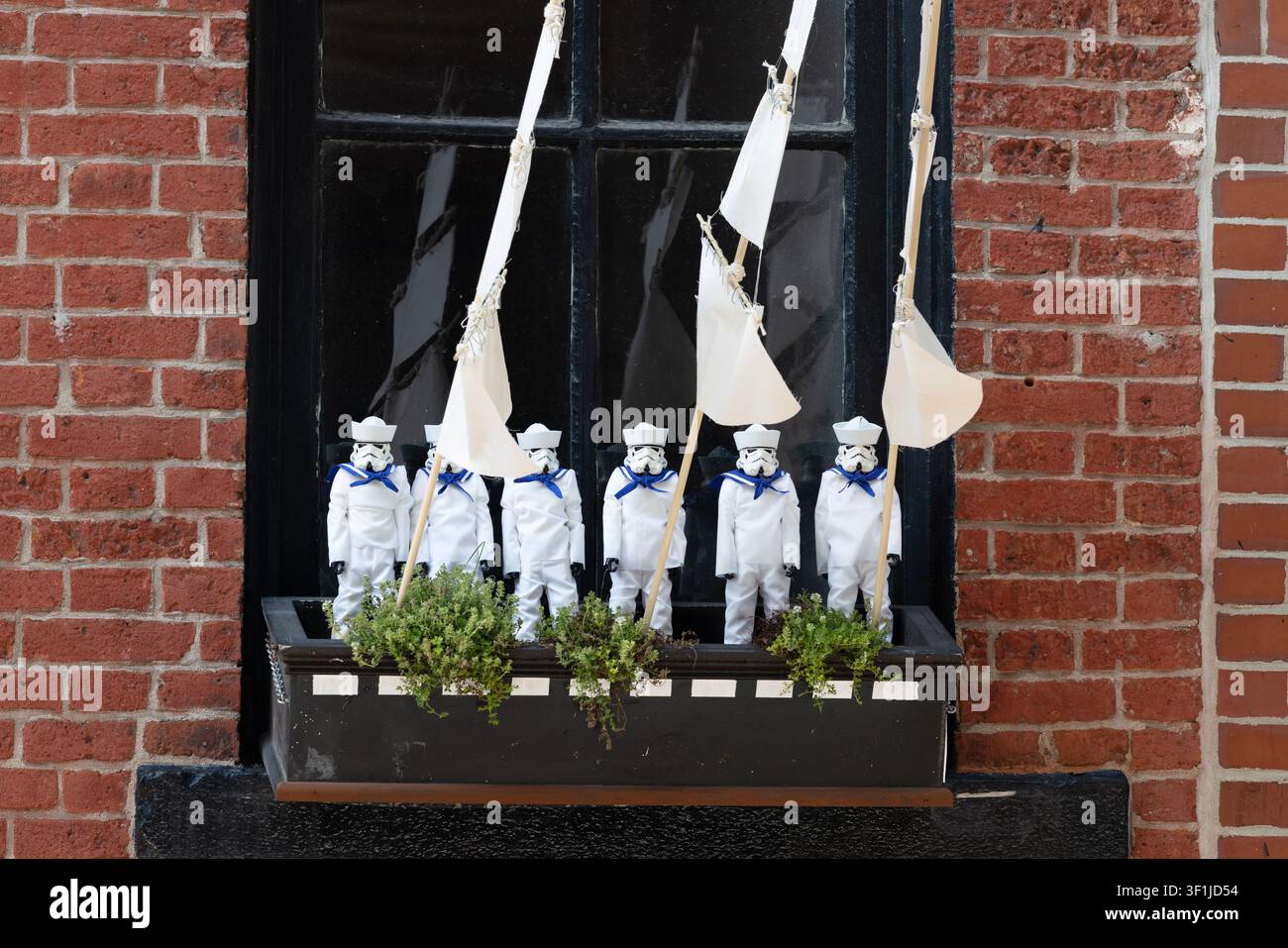 Espositore stravagante per finestra con piccole figure di giocattoli bianchi e bandiere su Beacon Hill a Boston, Massachusetts. Foto Stock