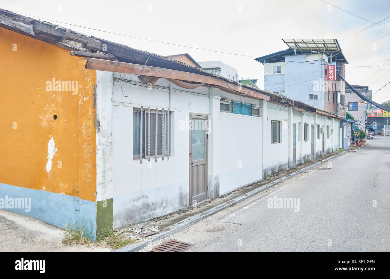 Casa a schiera a un piano logorata che mostra l'eredità architettonica industriale. Struttura residenziale autentica ideale per i media editoriali sul degrado urbano. Foto Stock