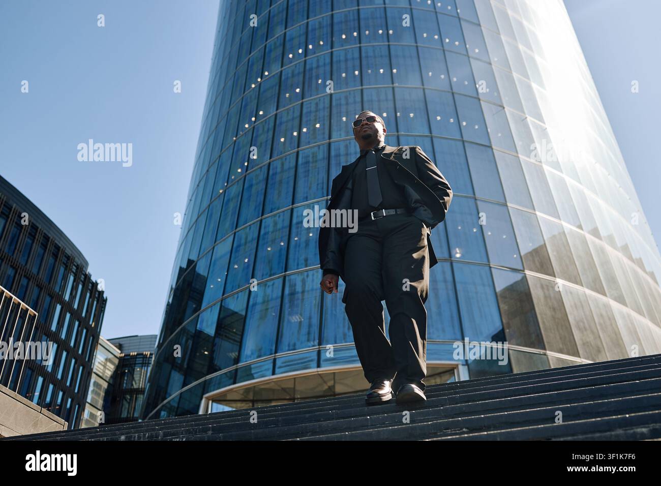 Uomo d'affari nero che scende le scale fuori dall'ufficio aziendale Foto Stock