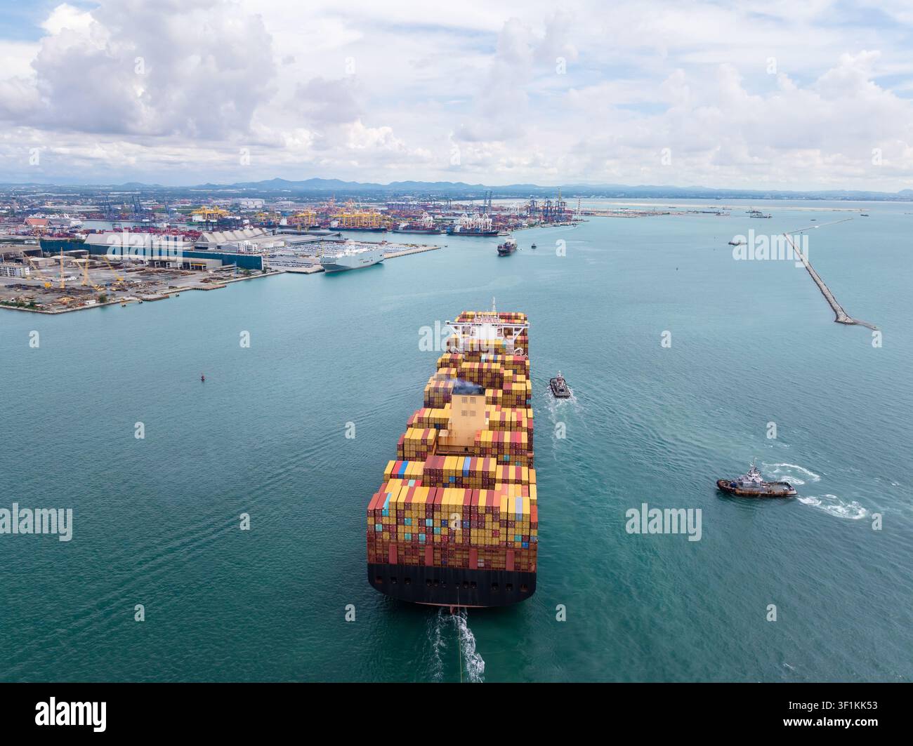 Un'enorme nave da carico che trasporta container di spedizione si muove in un terminal portuale industriale a Chon Buri, Thailandia. Foto Stock