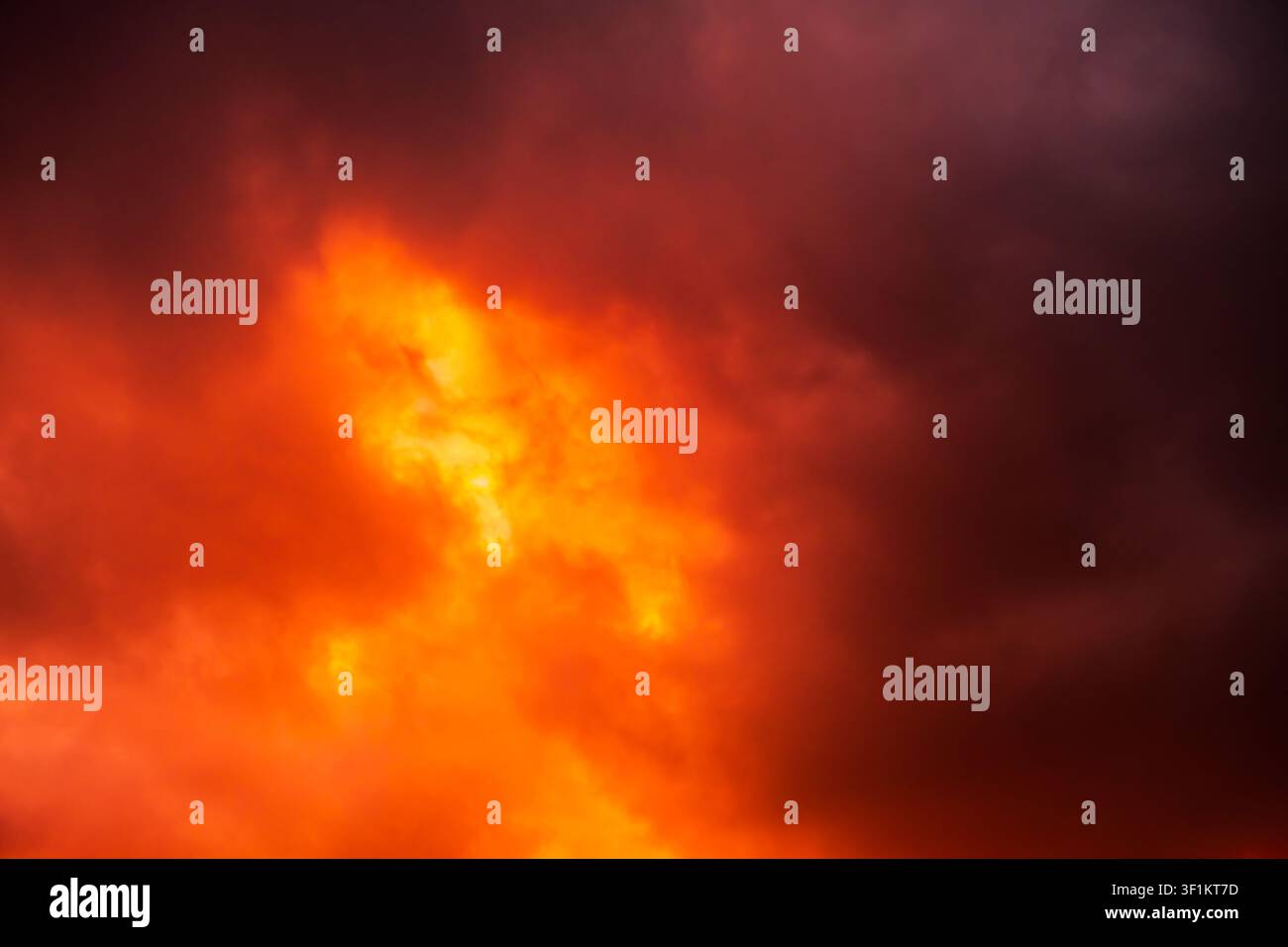 Cielo rosso scuro giallo arancio con nuvole. Cieli di tempesta cupi e drammatici. Sfondo con spazio per la progettazione. Fuoco vulcanico fulminante. Un brillante flash di esplosione Foto Stock