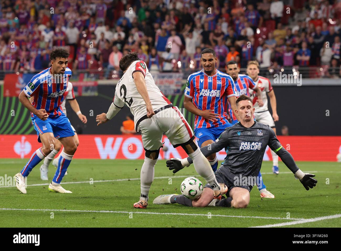 Dean Henderson del Crystal Palace FC nega ad Andrei Ratiu del Rayo Vallecano un'occasione di segnare mentre Chadi Riad e Maxence Lacroix del Crystal Palace FC loo Foto Stock