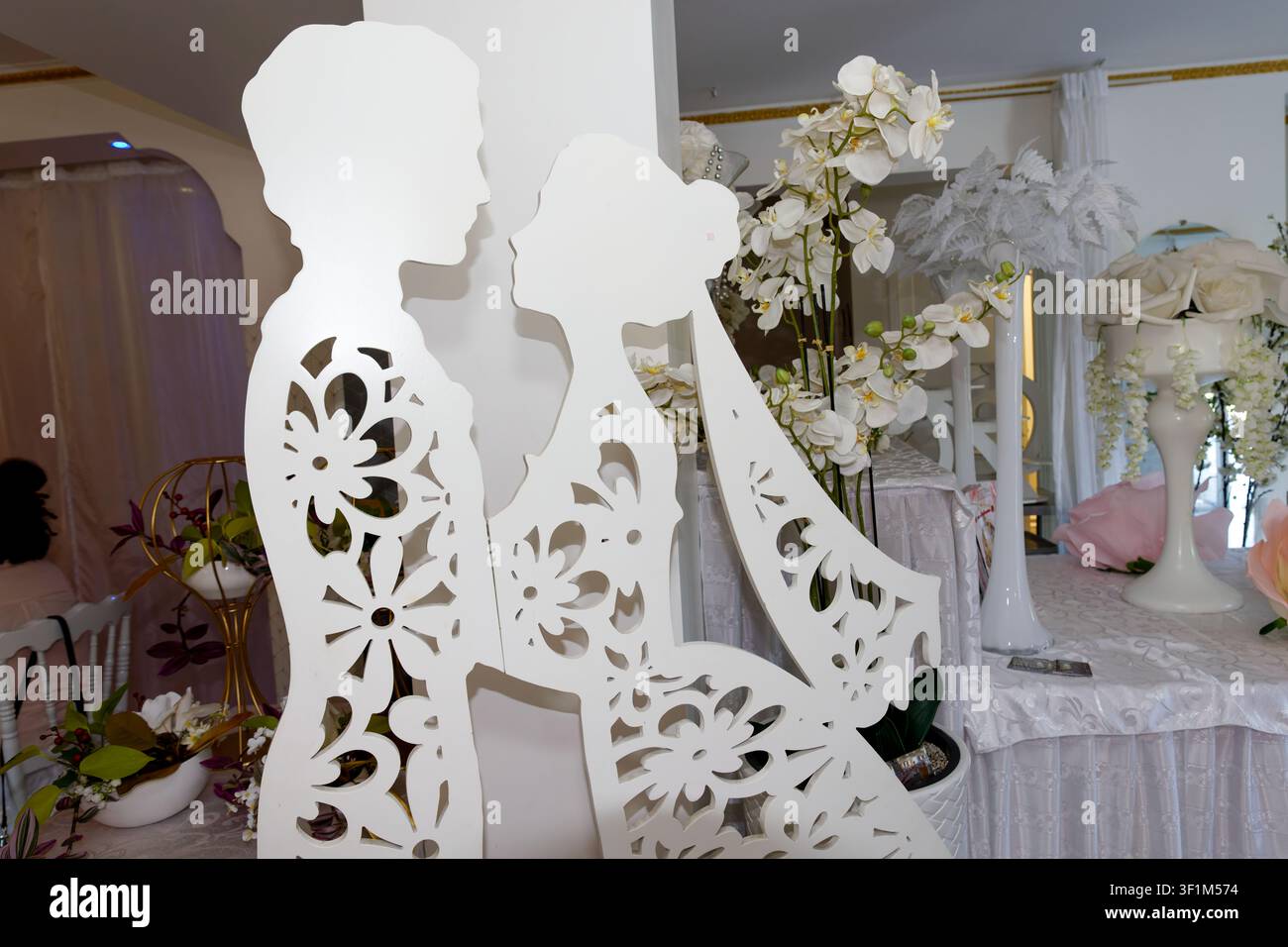 Silhouette decorativa bianca di sposa e sposo con design floreale ritagliato a una receptione di matrimonio Foto Stock
