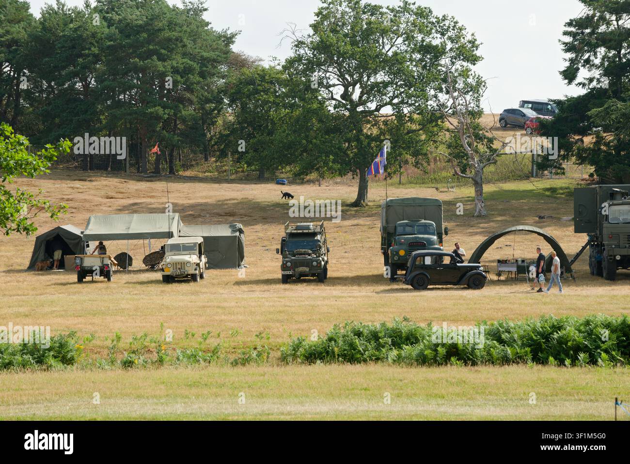 Una vecchia esposizione militare di equipaggiamento militare, tende e veicoli di tutte le dimensioni. Un accampamento di tende e vecchi veicoli. Foto Stock